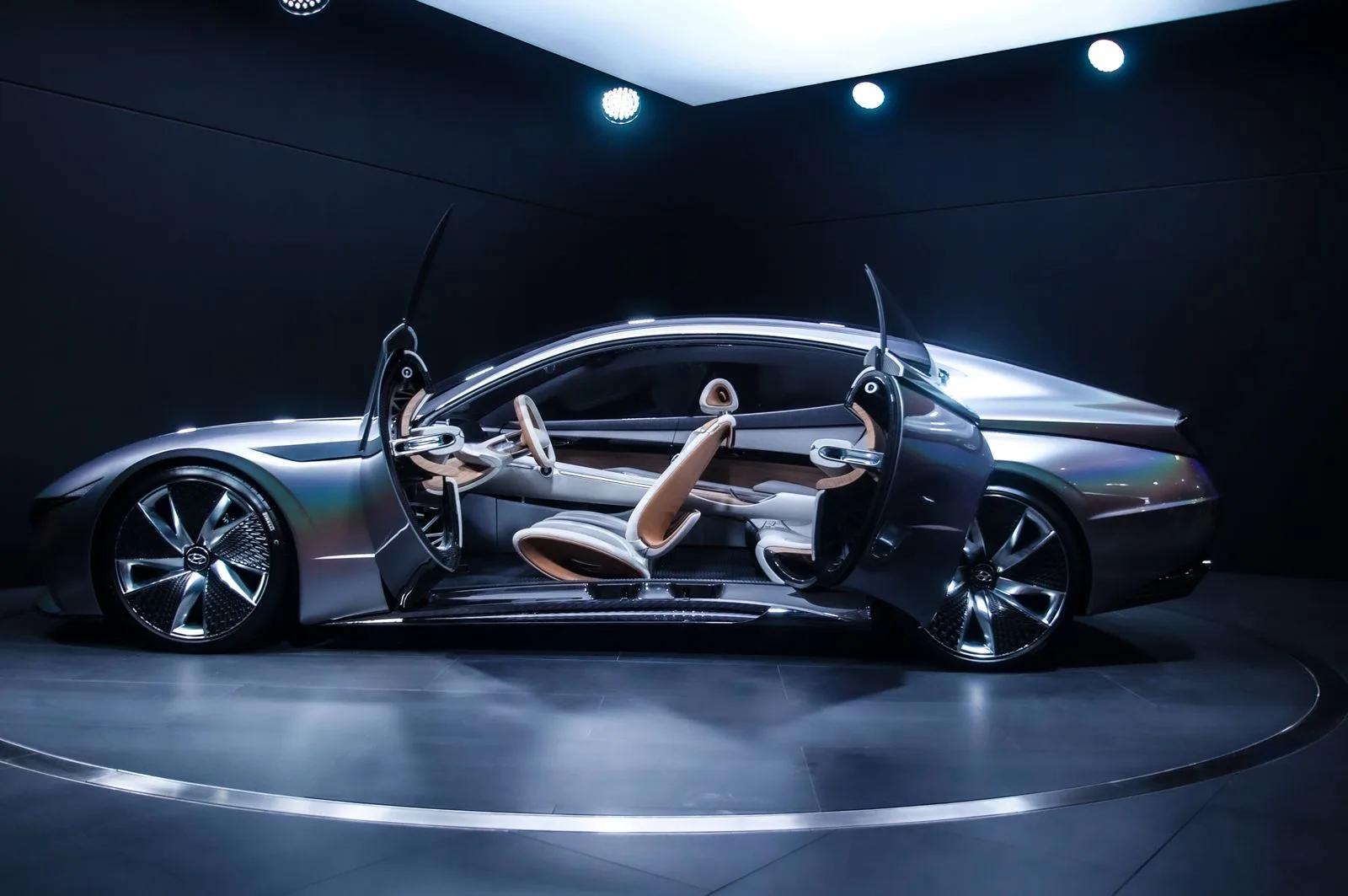 Concept-car argenté aux lignes sculptées et portières ouvertes, présenté en studio sous éclairage