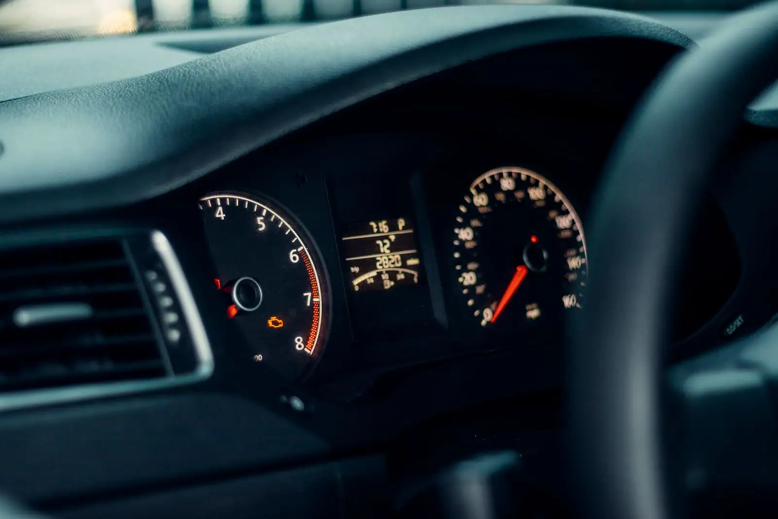 Combiné d'instruments d'une voiture en gros plan, compteur de vitesse et compte-tours.