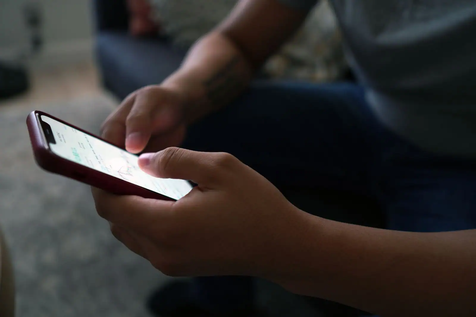 Personne consultant l'actualité sur l'écran d'un smartphone tenu à deux mains