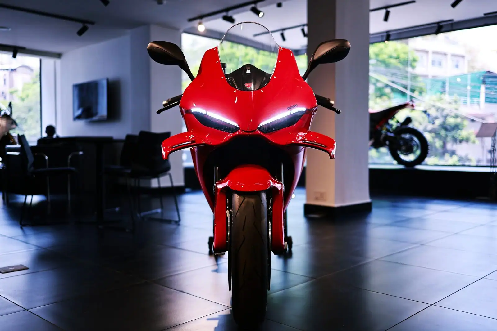 Moto sportive carénée rouge exposée de face dans le hall d'une concession