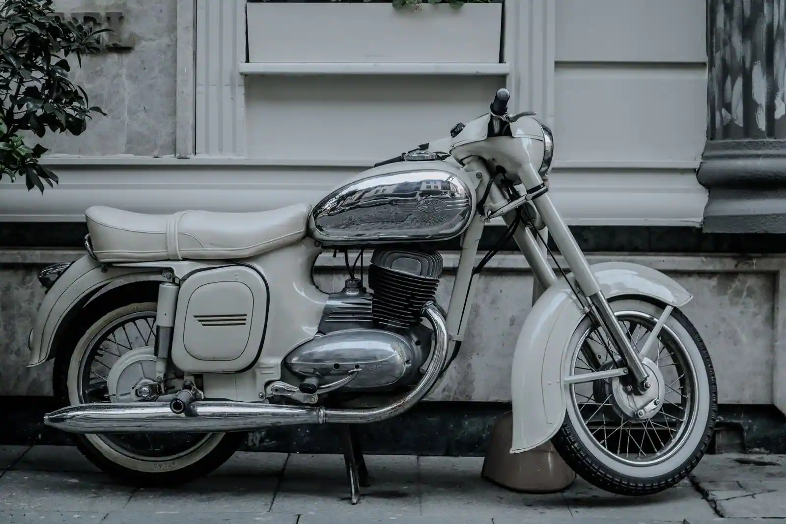 Moto classique au style rétro, vue de profil, garée le long d'un bâtiment dans une rue