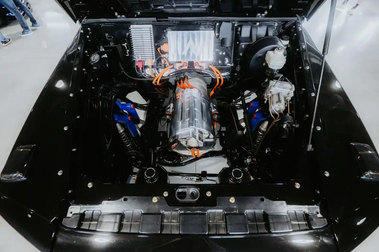 Moteur électrique et câblage haute tension orange installés dans le compartiment moteur ouvert d'une voiture