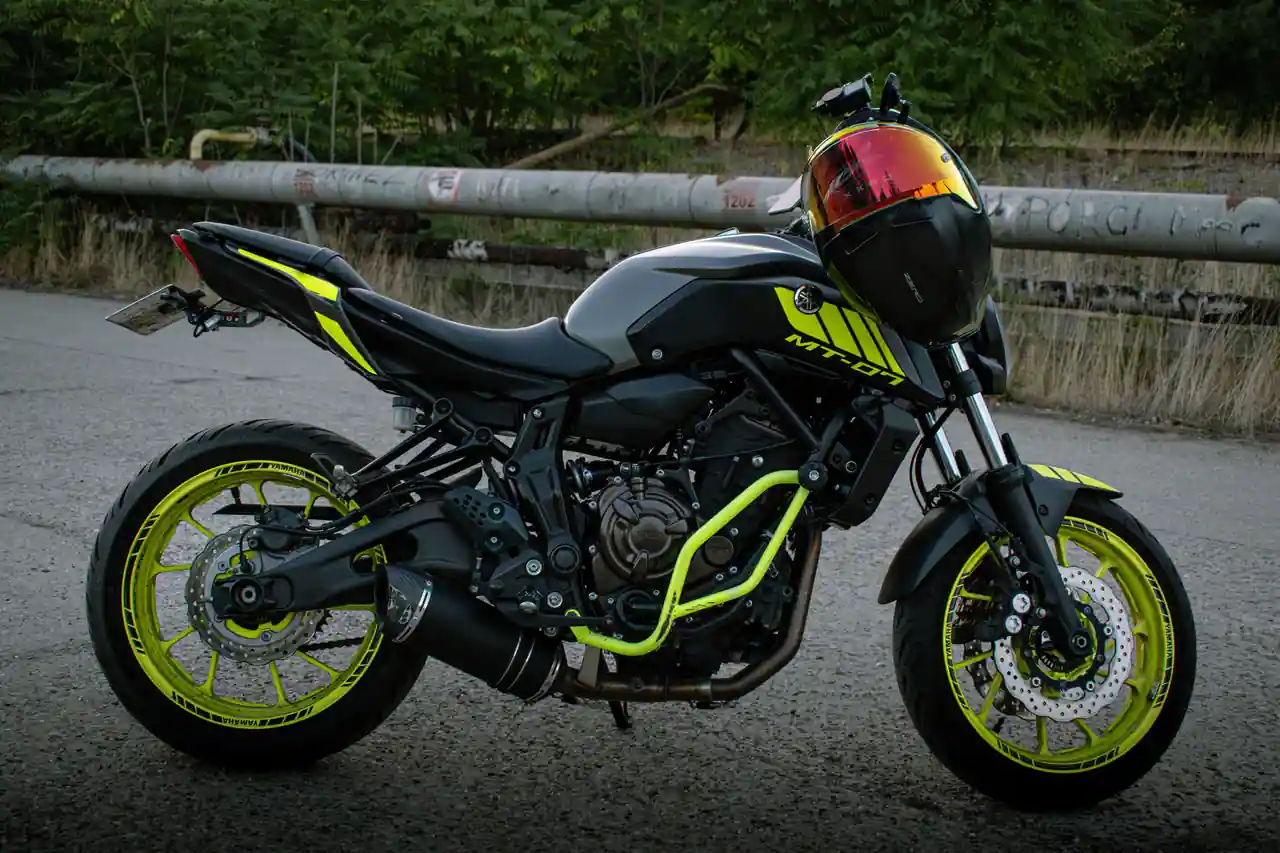 Moto roadster naked noire au moteur apparent, sans carénage, stationnée de profil