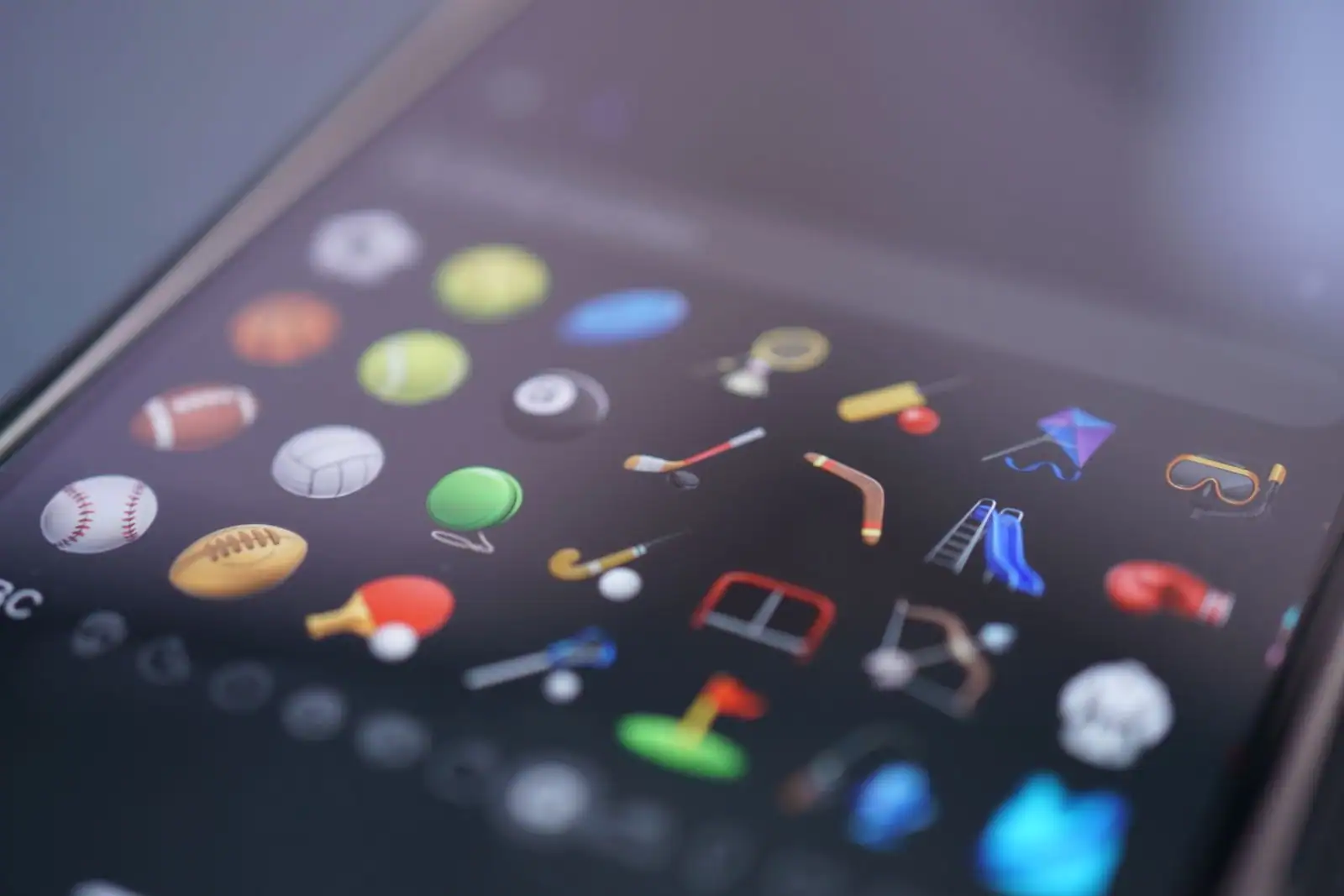 Gros plan d'un smartphone affichant à l'écran une grille d'icônes de sports colorées.
