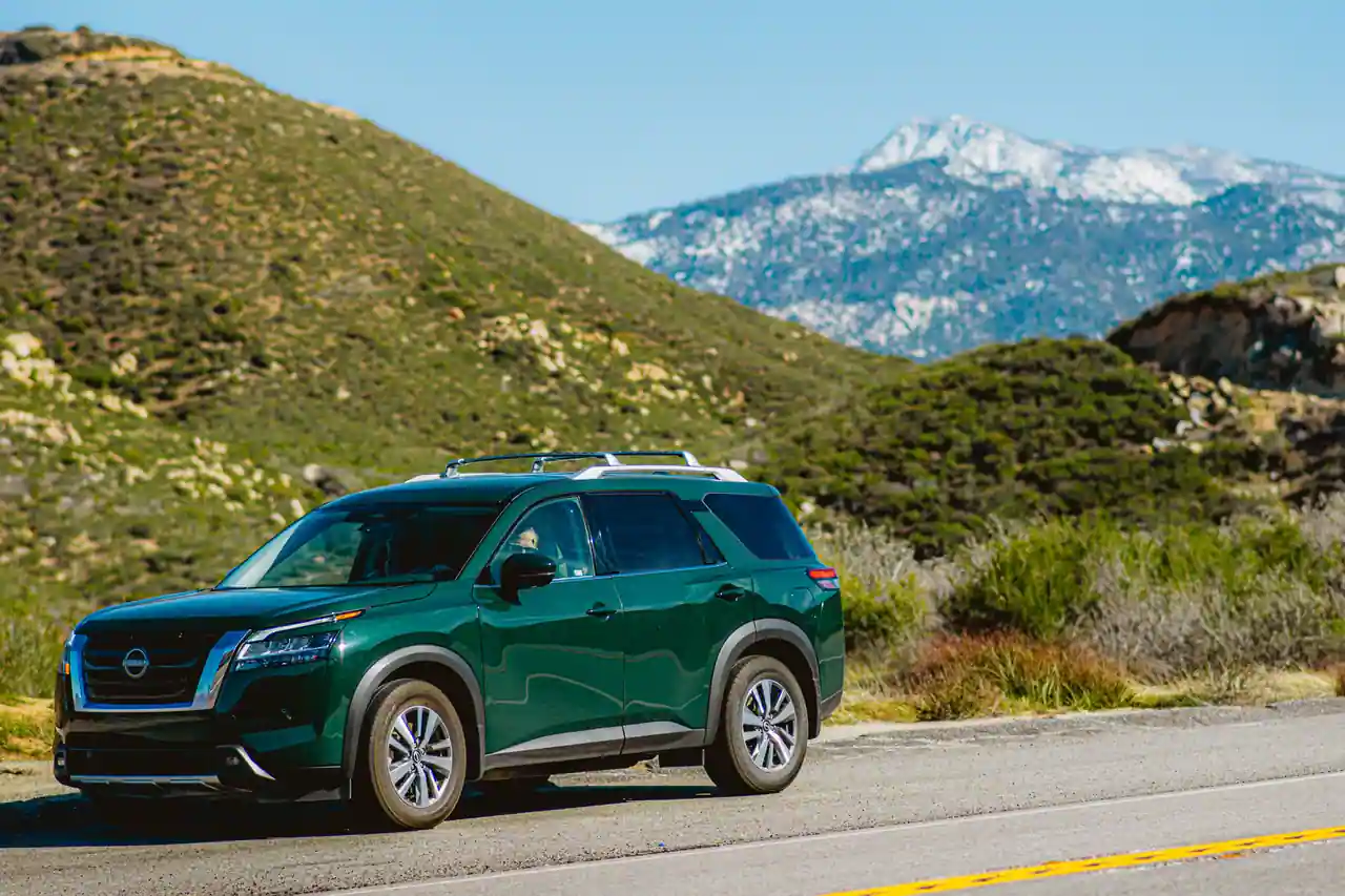 SUV Nissan de couleur verte sur une route de montagne, vue de trois quarts avant
