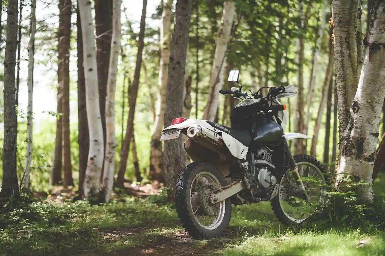 Moto trail garée sur un chemin de terre, prête pour une sortie mêlant route et pistes.