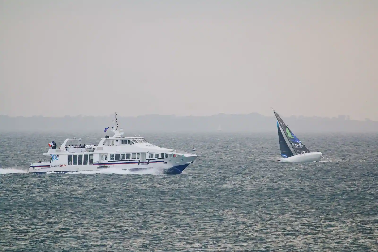 Navire à passagers de la Compagnie Océane en mer au large de la côte bretonne, un voilier à l’horizon