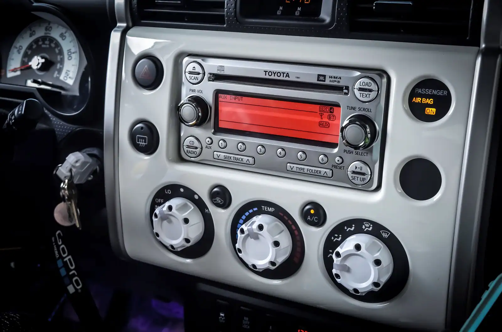 Autoradio d'origine à lecteur CD et écran monochrome sur la console centrale d'une voiture.