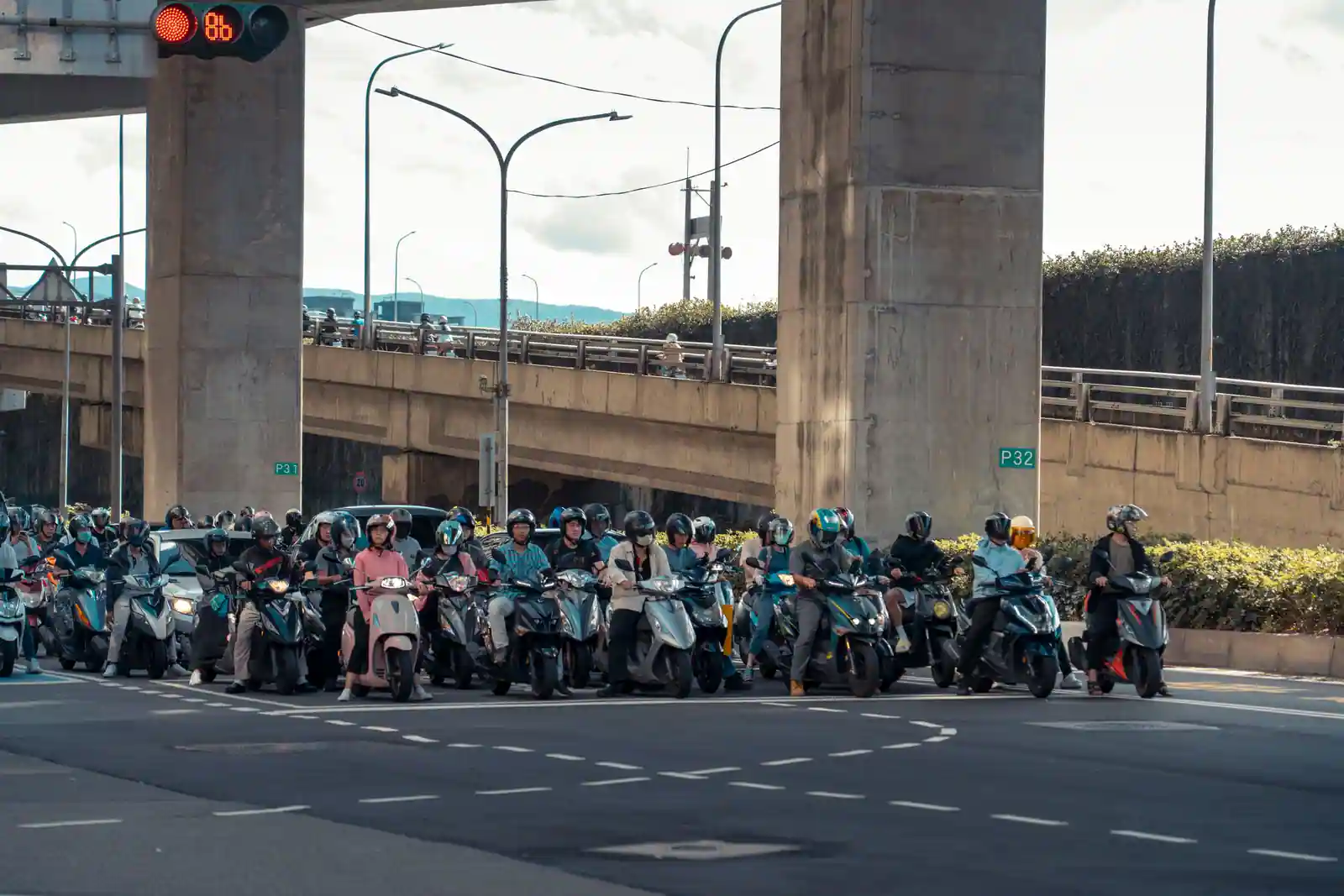 Peloton de scooters urbains à l'arrêt devant un feu à Taipei, où le deux-roues domine les trajets