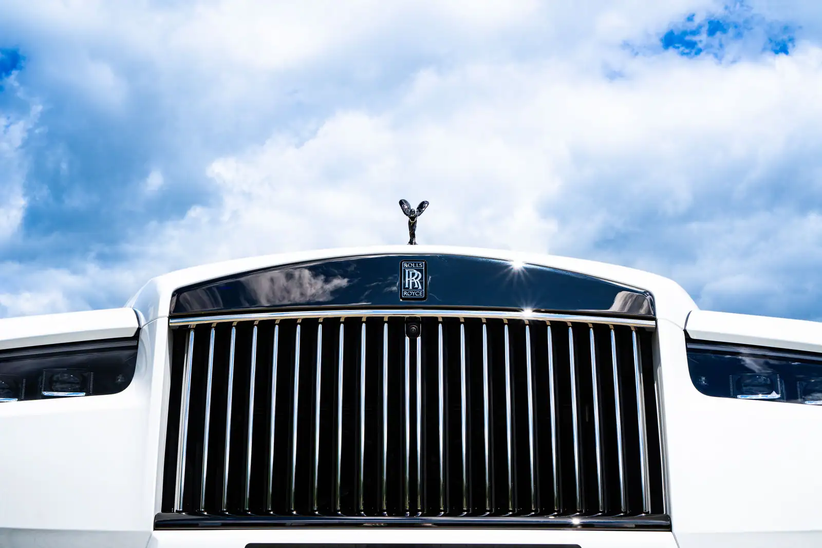 Calandre Pantheon chromée et statuette Spirit of Ecstasy sur le capot d'une Rolls-Royce blanche