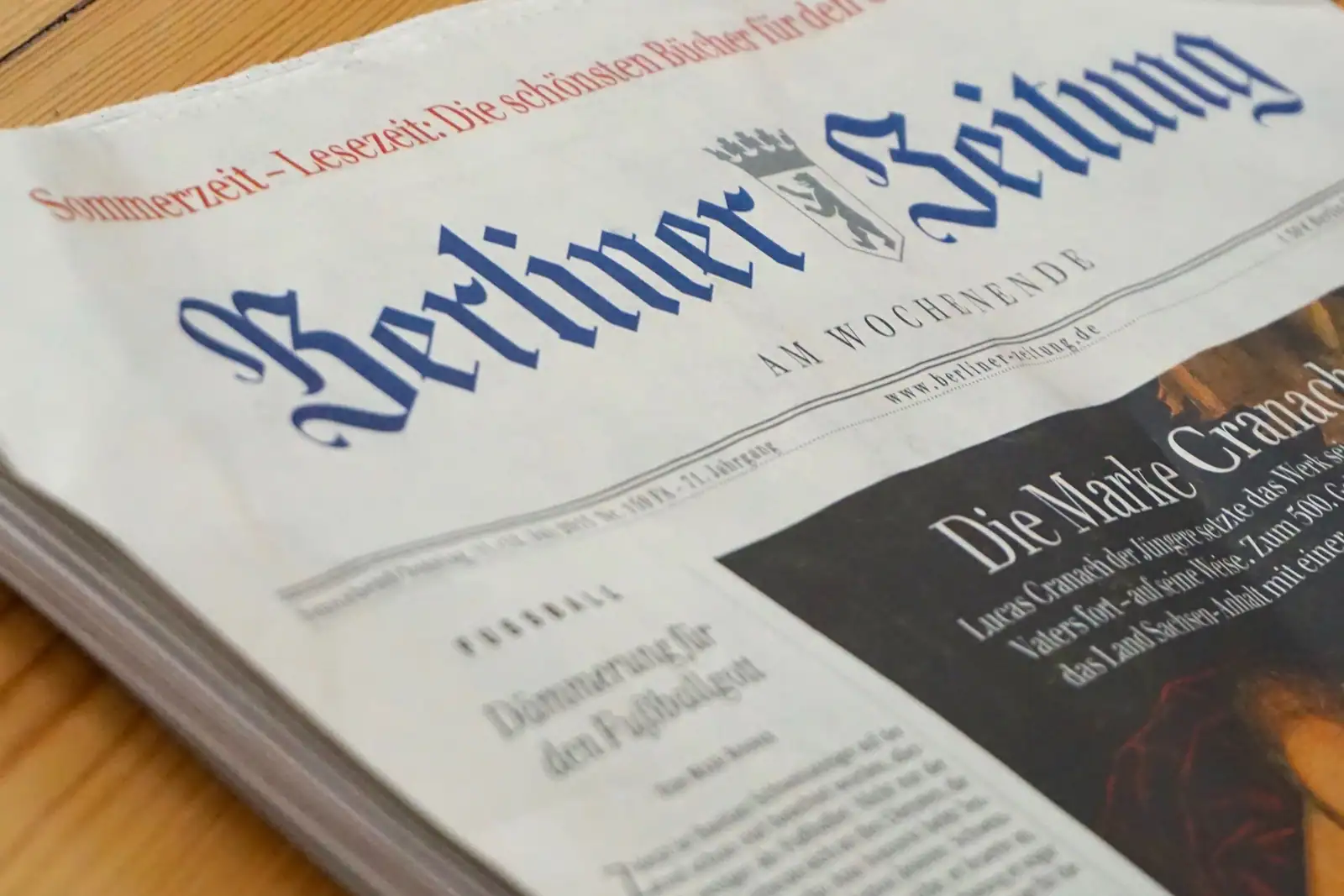 Une du quotidien régional Berliner Zeitung posée sur une table en bois, titre en caractères gothiques.