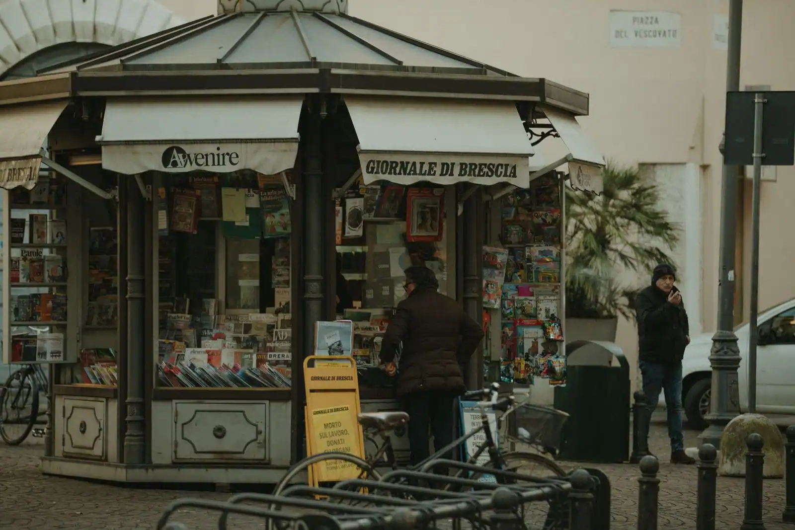 Kiosque à journaux italien avec des quotidiens exposés en devanture dans une rue de ville