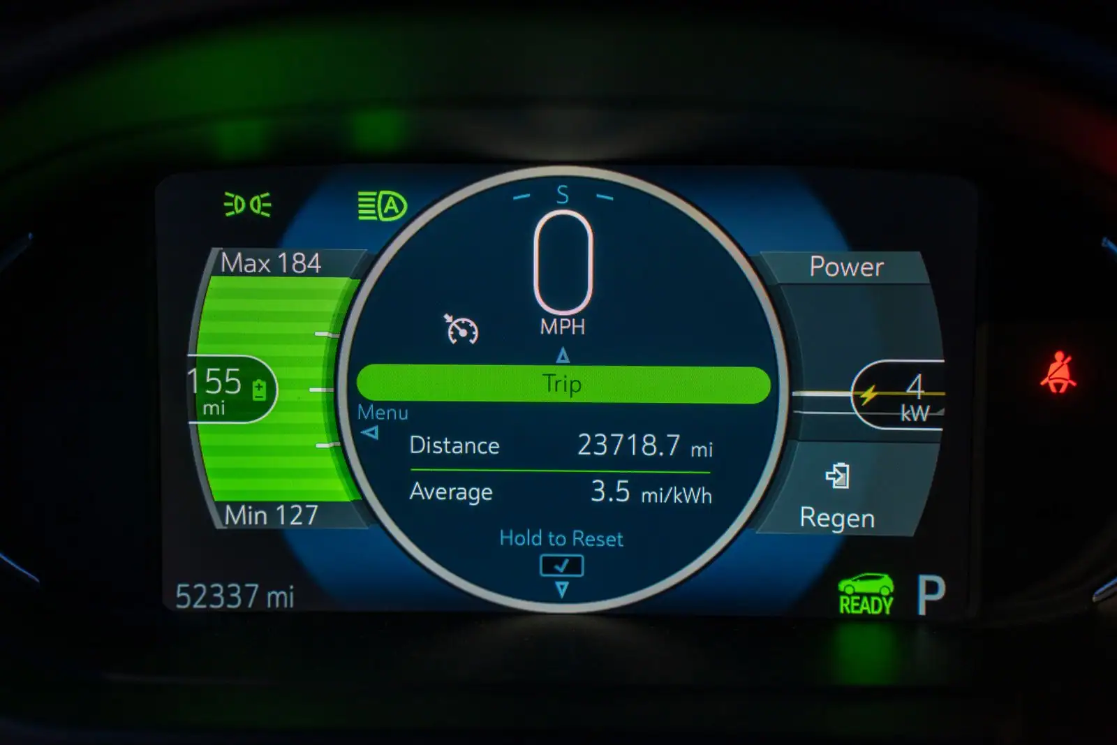 Tableau de bord numérique d'une voiture électrique affichant l'autonomie estimée et la puissance instantanée.